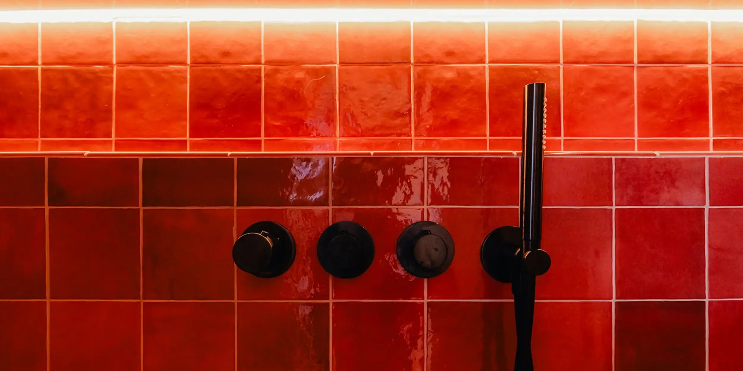 Artisan Burgundy wandtegels van 13,2 × 13,2 cm in de douche, met zwart kraanwerk en een verlichte nis